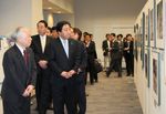 Photograph of the Prime Minister viewing photos with the guidance of Mr. Shigeru Yokota and his wife 1