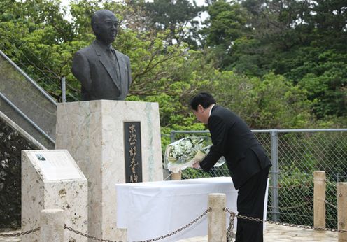 Photograph of the Prime Minister offering flowers to the bust of Mr. Ichiro Suetsugu