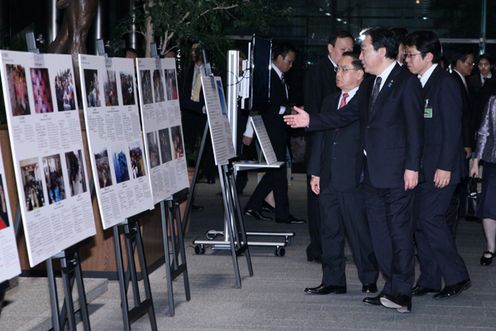 Photograph of Prime Minister Noda describing the exhibition of the photographs taken in the disaster-stricken areas to Prime Minister of Laos Thongsing Thammavong 1
