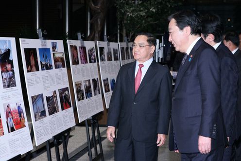 Photograph of Prime Minister Noda describing the exhibition of the photographs taken in the disaster-stricken areas to Prime Minister of Laos Thongsing Thammavong 2