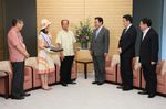 Photograph of the Prime Minister being presented with <i>kariyushi</i> shirts from the Governor of Okinawa Prefecture