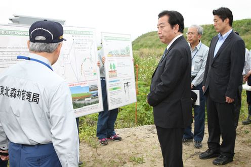 Photograph of the Prime Minister observing the site of the project to restore disaster-prevention forests along the coast