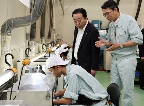 Photograph of the Prime Minister observing the production line of artificial joint products at a company in Okayama City