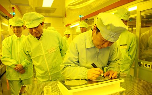 Photograph of the Prime Minister putting his signature on a wafer at a company in Fukuyama City