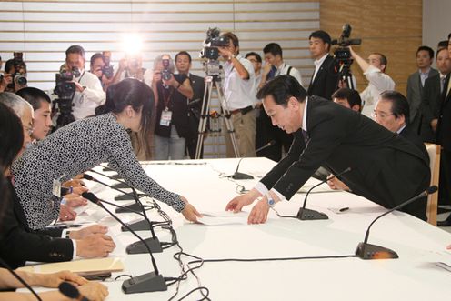 Photograph of the Prime Minister receiving a letter of request from citizens' groups and others