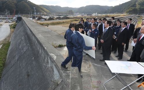 Photograph of the Prime Minister observing the coastal levee in Taro District 1