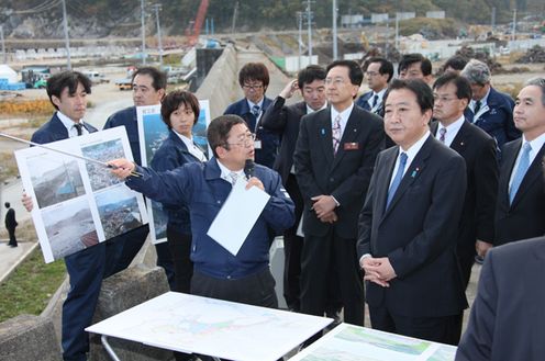 Photograph of the Prime Minister observing the coastal levee in Taro District 2