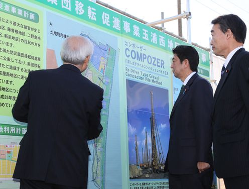 Photograph of the Prime Minister observing construction work for the development of areas for group transfer for disaster prevention