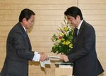 Photograph of the Prime Minister receiving the report of the joint statement by the government and the Bank of Japan