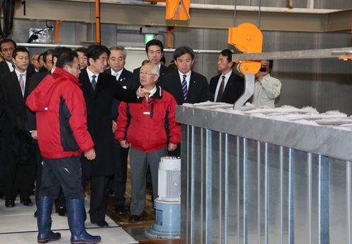 Photograph of the Prime Minister observing an ice-making factory