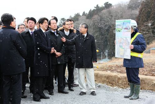 Photograph of the Prime Minister observing the construction work for the transfer of residential areas to plateaus