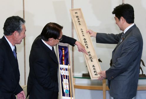 Photograph of the Prime Minister receiving the three arrows presented