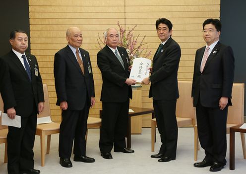 Photograph of the Prime Minister receiving a letter of request from JA Group