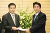 Photograph of Prime Minister Abe receiving a letter of request from the President of the National Governors' Association, Mr. Keiji Yamada