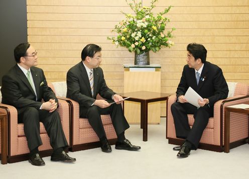 Photograph of Prime Minister Abe receiving a request from the President of the National Governors' Association, Mr. Keiji Yamada, and others