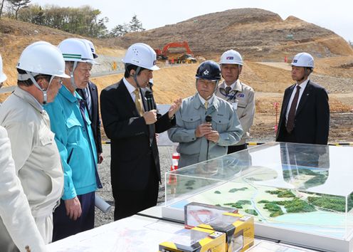 Photograph of the Prime Minister receiving an explanation on the group relocation promotion project for disaster mitigation and the land readjustment project in the Nobiru Hokubu Kyuryo area