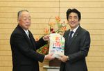Photograph of Prime Minister Abe being presented with rice from Mr. Motohoshi Yamada, Mayor of Hirono Town