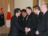 Photograph of the Prime Minister shaking hands with members of the New Zealand national rugby team, the 
