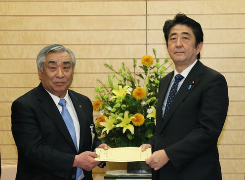 Photograph of the Prime Minister receiving a written declaration from Mr. Akiharu Tsuboi, President of the National Federation of Shopping Center Promotion Associations