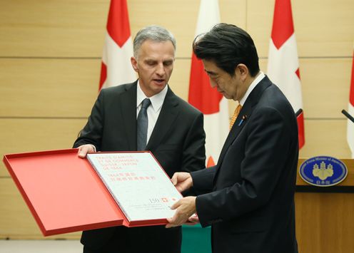 Photograph of the Prime Minister receiving a replica of the 1864 Treaty of Amity and Trade between Japan and Switzerland from the President