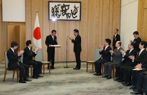 Photograph of Prime Minister Abe presenting the Prime Minister's certificate of appreciation and applauding Mr. Ryotaro Sugi