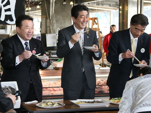 Photograph of the Prime Minister sampling fish caught off the coast of Iwaki City