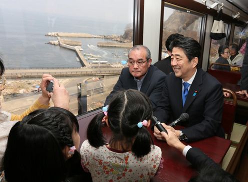 Photograph of the Prime Minister conversing with passengers in a railcar of the Sanriku Railway (2)