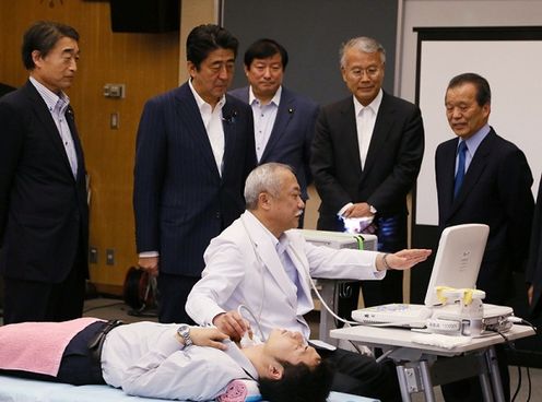 Photograph of the Prime Minister receiving an explanation regarding the management of the impact of radiation on health