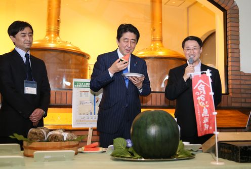Photograph of the Prime Minister tasting a local specialty
