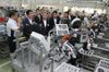 Photograph of the Prime Minister observing a production line in which dual-arm production robots have been introduced