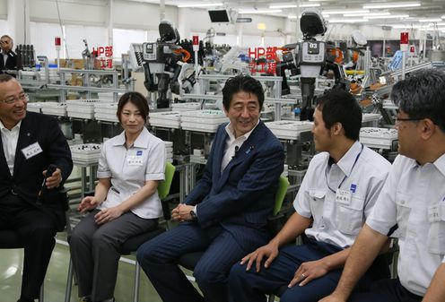 Photograph of the Prime Minister exchanging opinions with factory workers and others