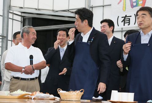 Photograph of the Prime Minister tasting cabbage and other local produce