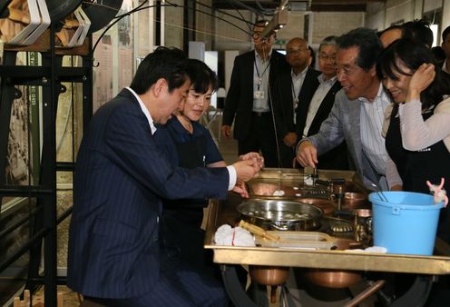 Photograph of the Prime Minister reeling silk at Tomioka Silk Mill (1)