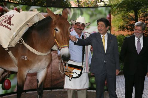 Photograph of the Prime Minister having a photograph taken with the mascot of Café de Colombia