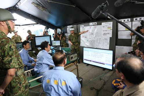 Photograph of the Prime Minister receiving a report on activities at the on-site coordination center