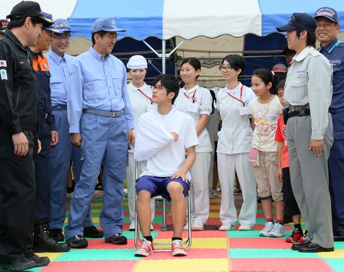 Photograph of the Prime Minister receiving an explanation of an emergency relief drill using slings