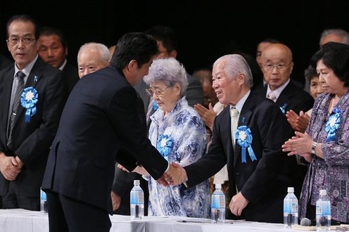 Photograph of the Prime Minister shaking hands with Mr Shigeru Yokota and other family members of the abductees