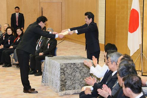 Photograph of the Prime Minister presenting a certificate of award