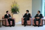 Photograph of the Prime Minister hearing a report from Mr. Uichiro Niwa