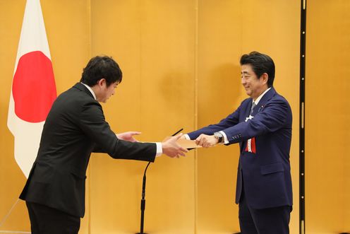 Photograph of the Prime Minister presenting a certificate of award