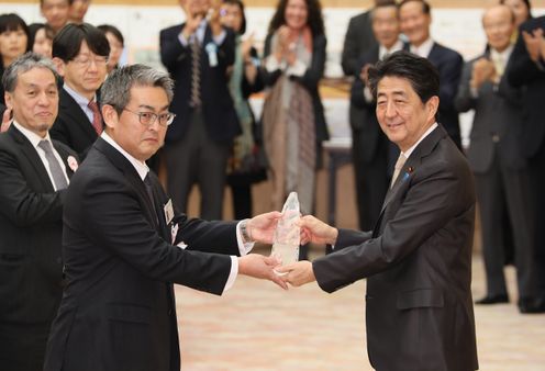 Photograph of the Prime Minister presenting a plaque