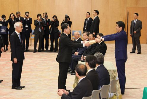 Photograph of the Prime Minister presenting a certificate of award