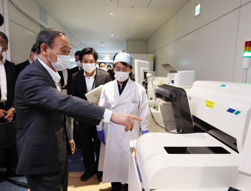 Photograph of the Prime Minister observing quantitative antigen tests (3)