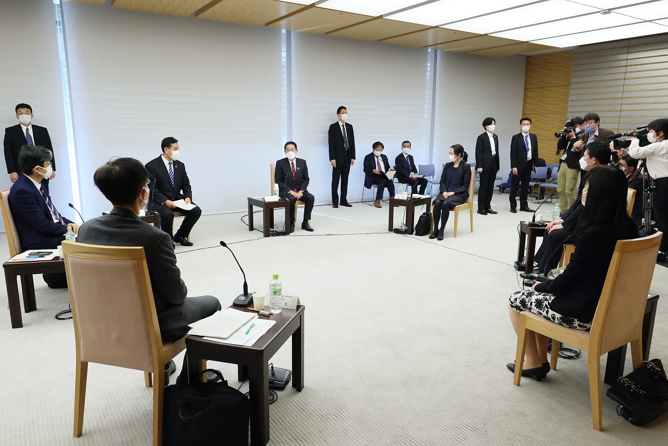 Photograph of the Prime Minister sitting down to talk with a small group of people (3)
