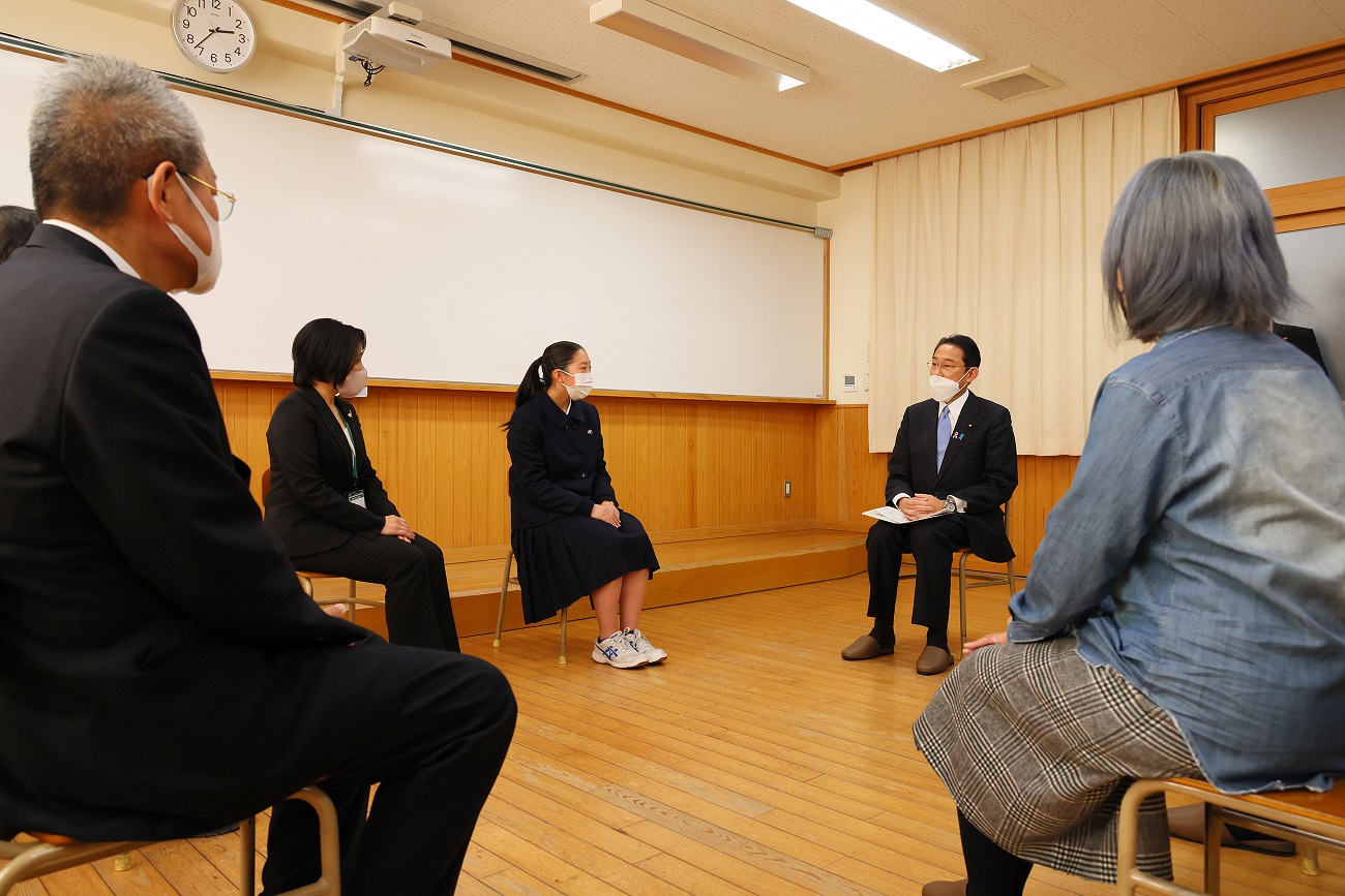 Photograph of the Prime Minister sitting down to talk with a small group of people (2)