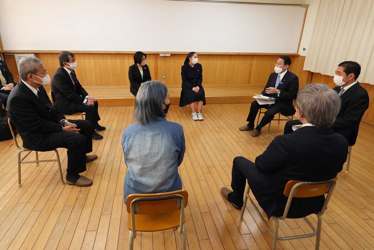 Photograph of the Prime Minister sitting down to talk with a small group of people (5)