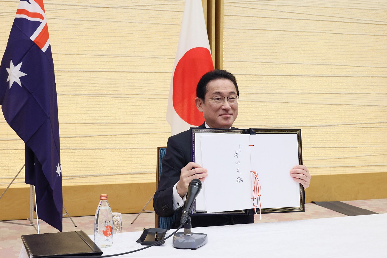 Photograph  of the Prime Minister holding up a signed document (2)