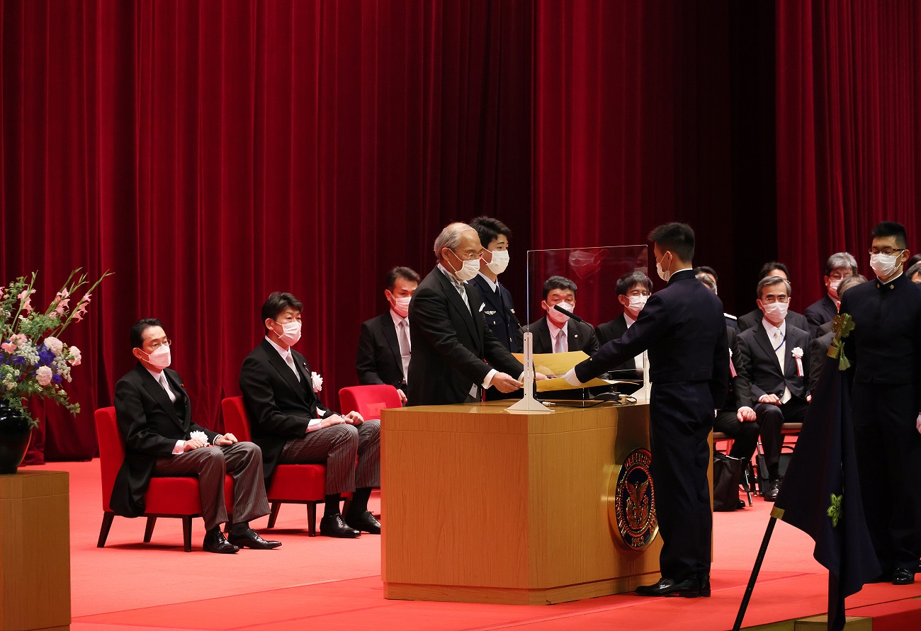 Photograph of the Prime Minister watching over the presentation of a diploma