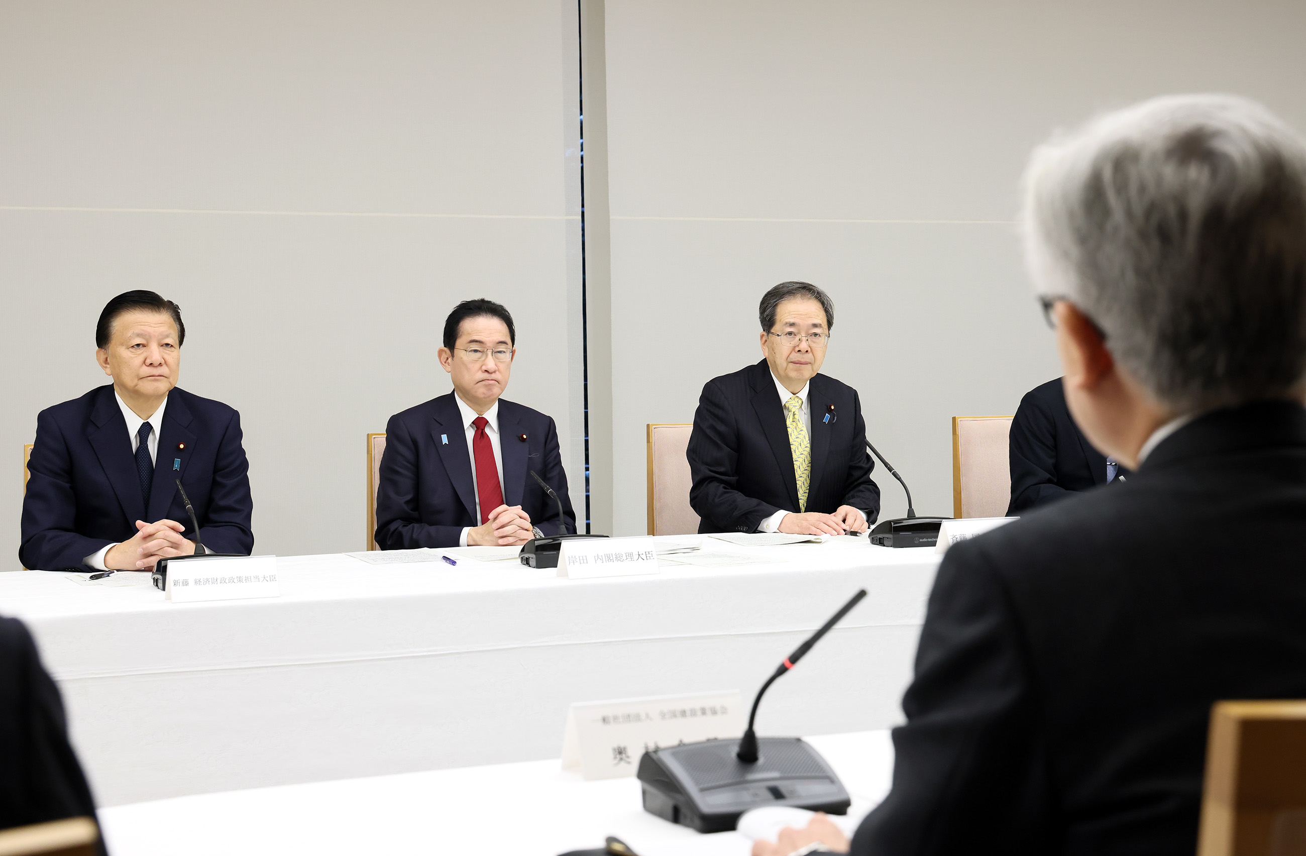 Prime Minister Kishida listening to participants at an exchange of views