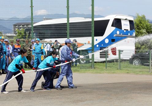 Photograph of the Prime Minister participating in the fire hose drill